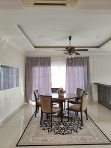 - une table à manger avec des chaises et un ventilateur de plafond dans l'établissement Sweet Cenang Memories Inn, à Pantai Cenang