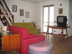 a living room with a couch and a tv at La Casa Di Baba' in Alfiano Natta