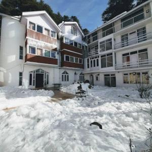 a pile of snow in front of a large building at Hotel New Broadway in Patnitop
