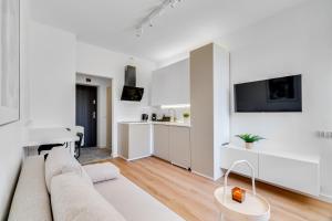 a white living room with a couch and a table at Hann Haven Apartments Armii krajowej 16 in Opole