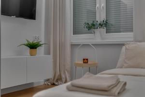 a bedroom with a bed and a window with a plant at Hann Haven Apartments Armii krajowej 16 in Opole