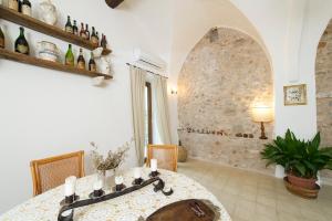 een eetkamer met een tafel en een stenen muur bij Agriturismo Masseria Pozzo in Sperlonga