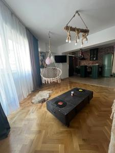 a living room with a table on a wooden floor at Rosa Apartment in Drobeta-Turnu Severin