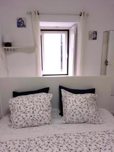 ein Schlafzimmer mit einem Bett mit zwei Kissen und einem Fenster in der Unterkunft Lisbon Lovers in Lissabon