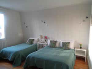 ル・クロトワにあるvacances 34のベッドルーム(ベッド2台、緑の掛け布団付)