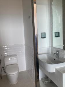 bagno con servizi igienici bianchi e lavandino di P.H.O Apartment a Phu Quoc