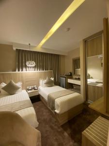 una camera d'albergo con 2 letti e una scrivania di Twins Boutique Hotel ad Aqaba