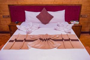 Una cama con dos toallas y un vestido. en New saniro Lagoon Deck en Katunayaka