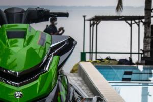 a green motorcycle parked next to a swimming pool at New saniro Lagoon Deck in Katunayaka