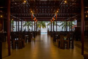 a dining room with tables and chairs in a building at New saniro Lagoon Deck in Katunayake