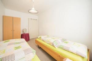 1 dormitorio con 2 camas individuales y lámpara en Sonniges Apartment mit Balkon, Smart-TV & Hue automatic lighting en Davos