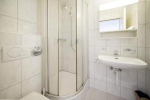 a white bathroom with a shower and a sink at Sonniges Apartment mit Balkon, Smart-TV & Hue automatic lighting in Davos