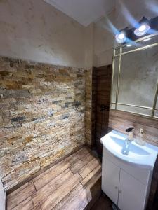 a bathroom with a sink and a brick wall at Rosa Apartment in Drobeta-Turnu Severin