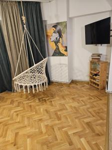 a living room with a hammock in a room with wooden floors at Rosa Apartment in Drobeta-Turnu Severin