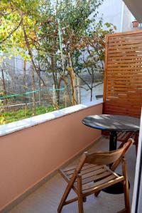 a table and a chair sitting in front of a window at Pogradec Sunilio Apartment in Pogradec