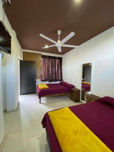 a bedroom with two beds and a ceiling fan at Cabañas El Sabinito in El Naranjo