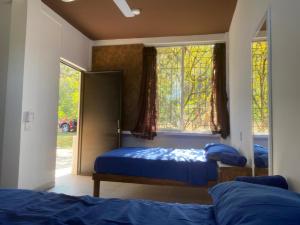 a bedroom with two beds and a window at Cabañas El Sabinito in El Naranjo