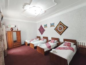 a hotel room with four beds and a chandelier at World Guest House in Samarkand +121 photos