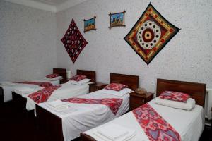 a group of four beds in a room at World Guest House in Samarkand