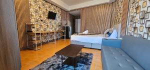 um quarto de hotel com uma cama e um sofá em XCESS RESIDENCE em Pattaya Sul