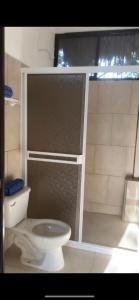 een badkamer met een wit toilet en een raam bij Cabañas El Sabinito in El Naranjo
