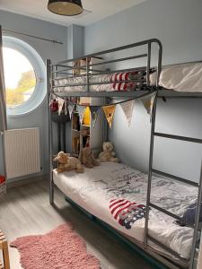 a bedroom with a bunk bed with two teddy bears at La Maison Bateau au Bord de Mer in Guissény