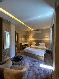 Habitación de hotel con cama y sofá en Twins Boutique Hotel en Áqaba