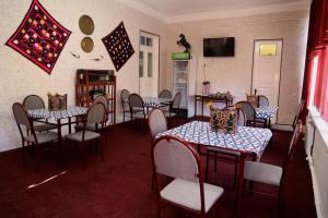 a dining room with tables and chairs and a tv at World Guest House in Samarkand