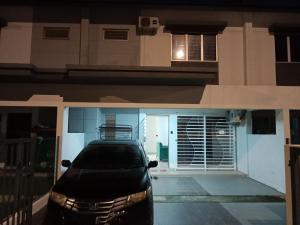 a car parked in front of a house at night at Iyad Guest House in Banting