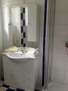y baño con lavabo blanco y ducha. en Pension Carina, en Sankt Kanzian