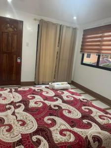 a bedroom with a large red and white rug on the floor at Stefanie Grace Paradise Inn in Loboc