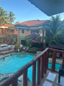 balcone con vista sulla piscina di un resort di Stefanie Grace Paradise Inn a Loboc