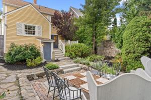 a patio with chairs and a table in front of a house at The Garden Downtown Steps to Waterfront in Newburyport