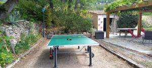 uma mesa de pingue-pongue num jardim com uma mesa em Villa conviviale au soleil avec piscine em Seillans
