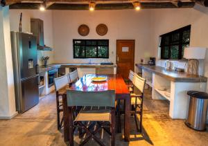 y cocina con mesa, sillas y nevera. en Bush Villas on Kruger en Phalaborwa