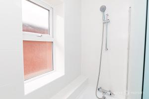 a shower in a bathroom with a window at Spacious & modern 3 bed, 10 min to beach, parking - Lyell House in Poole