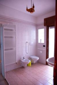 a white bathroom with a toilet and a sink at Peaceful Portello home in Padova