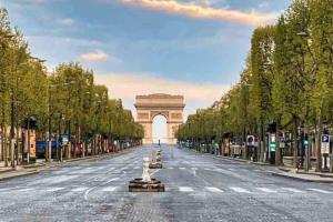 an empty street with an arch in the distance at Cozy studio@Champs Élysée in Paris