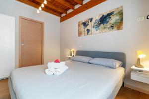 “Antica terrazza” Charme&relax في بيرغامو: غرفة نوم بسرير ابيض عليها مناشف