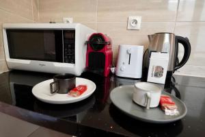 a counter top with a microwave and two coffee cups at Cozy studio@Champs Élysée in Paris