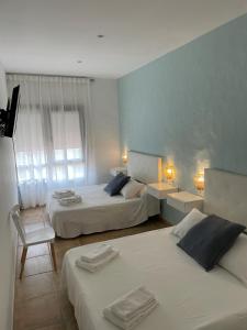 una habitación de hotel con 2 camas y una silla en El Escondido de Zahara en Zahara de los Atunes