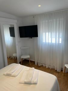 a bedroom with a bed with two white towels on it at El Escondido de Zahara in Zahara de los Atunes