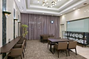 a dining room with tables and chairs and a projection screen at Hotel NCB in Osaka