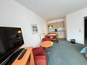 a living room with a table and a kitchen at Appartementhaus Westphal Fehmarn in Fehmarn