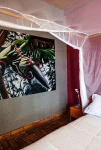 a bedroom with a painting on the wall at Susa Gardens in Ruhengeri