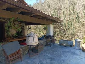 an outdoor patio with a grill and a wooden roof at Haraneko Errota Burdindegi in El Cerco