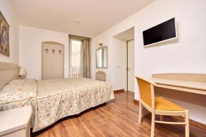 Habitación de hotel con cama y escritorio en Hotel San Marco, en Malcesine