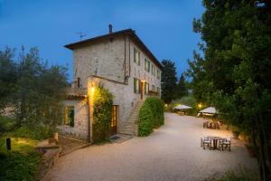 an old building with tables and chairs in a courtyard at Agriturismo Cuore Verde Olmo in Spello