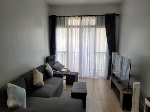 a living room with a couch and a television at Decent and cosy one bed flat - Bella Vista in Entebbe