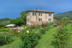 a building with a bunch of flowers in front of it at Agriturismo Cuore Verde Olmo in Spello +21 photos